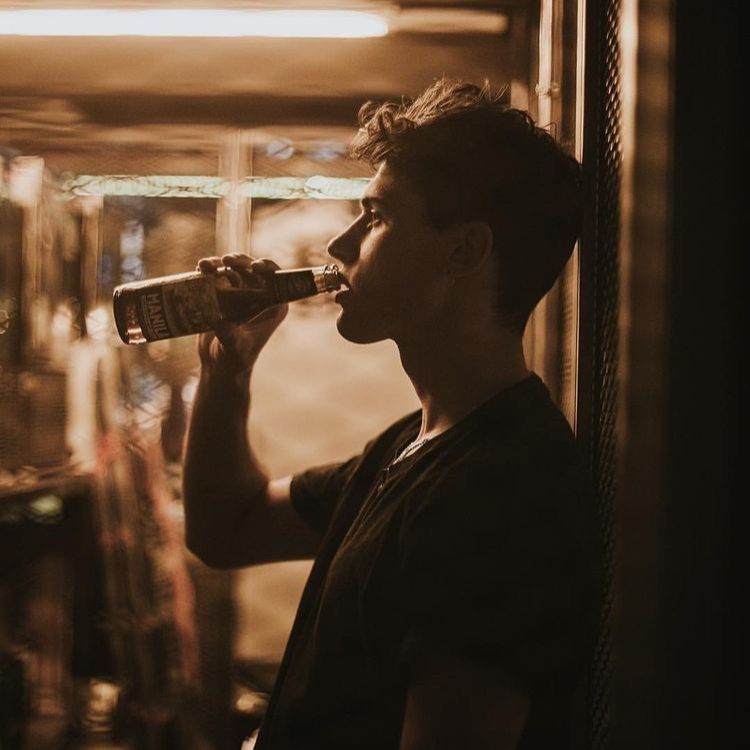 hình ảnh uống rượu buồn chàng trai dựa tường