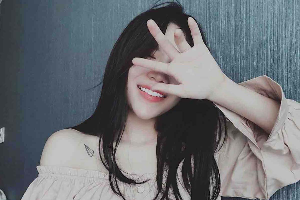 Dùng tay hoặc tóc để che đi một phần mặt