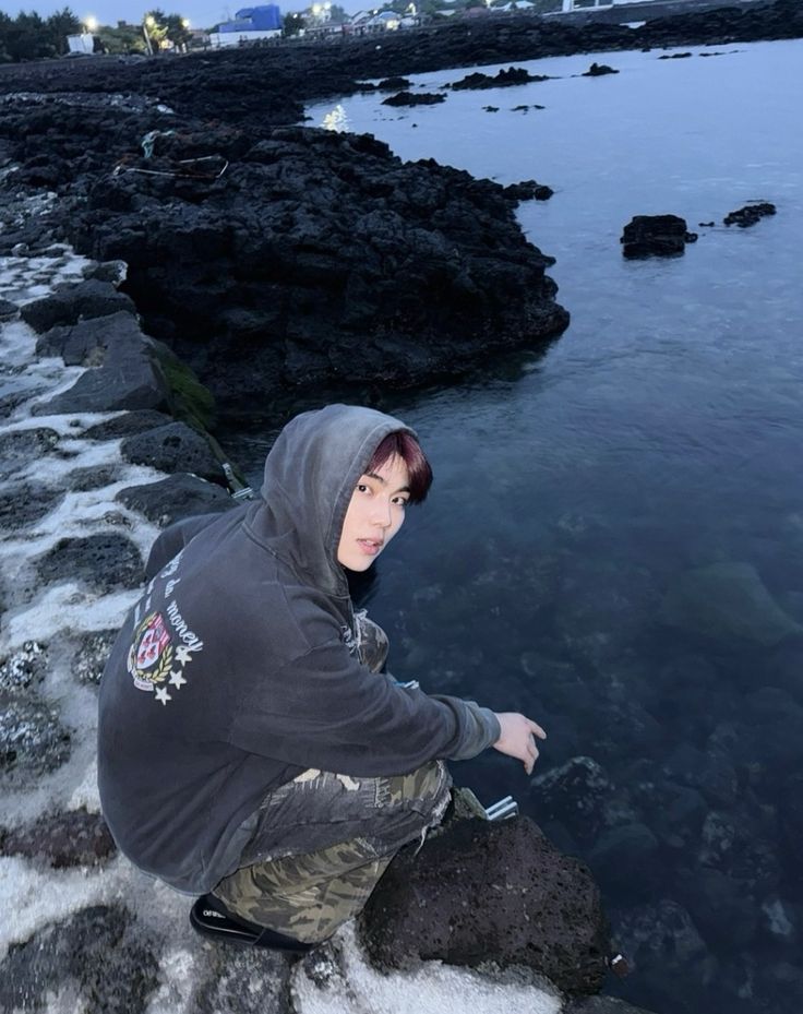 Ngồi xổm nhìn vỏ sò trên cát