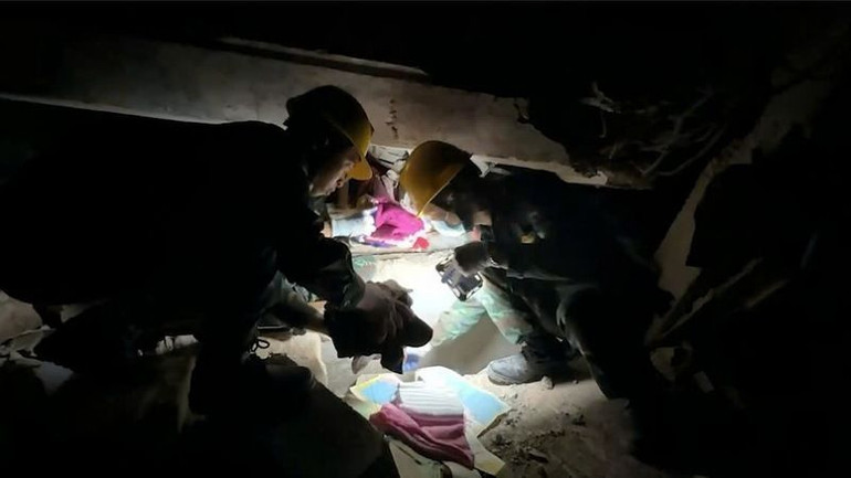 Nhận thi thể của cha được Bộ đội Việt Nam đưa ra từ đống đổ nát, con trai cụ U Maung Tin xúc động nói: "Tôi đã nghĩ là không thể đưa được cha tôi ra ngoài, vậy mà các bạn đã làm được. Tôi xúc động không biết nói gì hơn. Xin cảm ơn các bạn rất nhiều". (Ảnh: Báo Quân đội nhân dân)