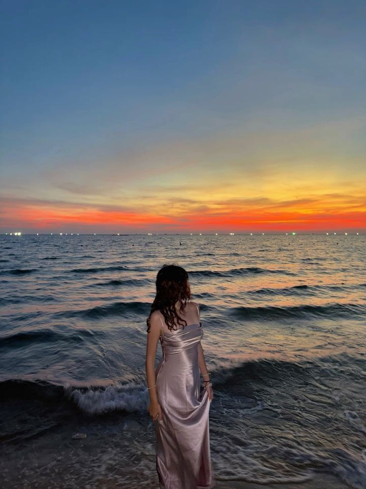 Tay nâng tà váy khi đi bộ trên bãi biển đầy nắng