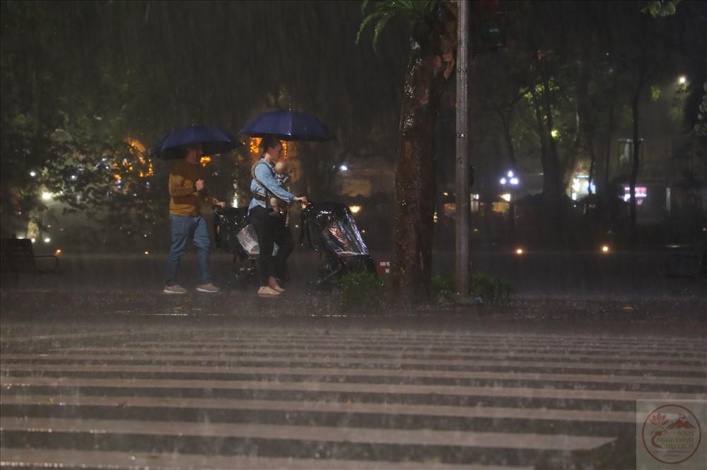 Ánh đèn vàng phản chiếu trên phố mưa đêm Hà Nội thật lung linh