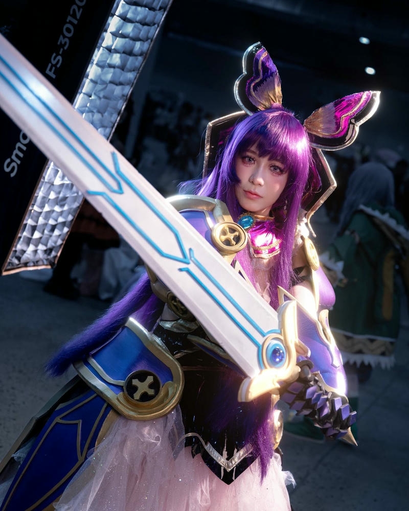 Gái xinh cosplay chiến binh tóc tím cầm vũ khí