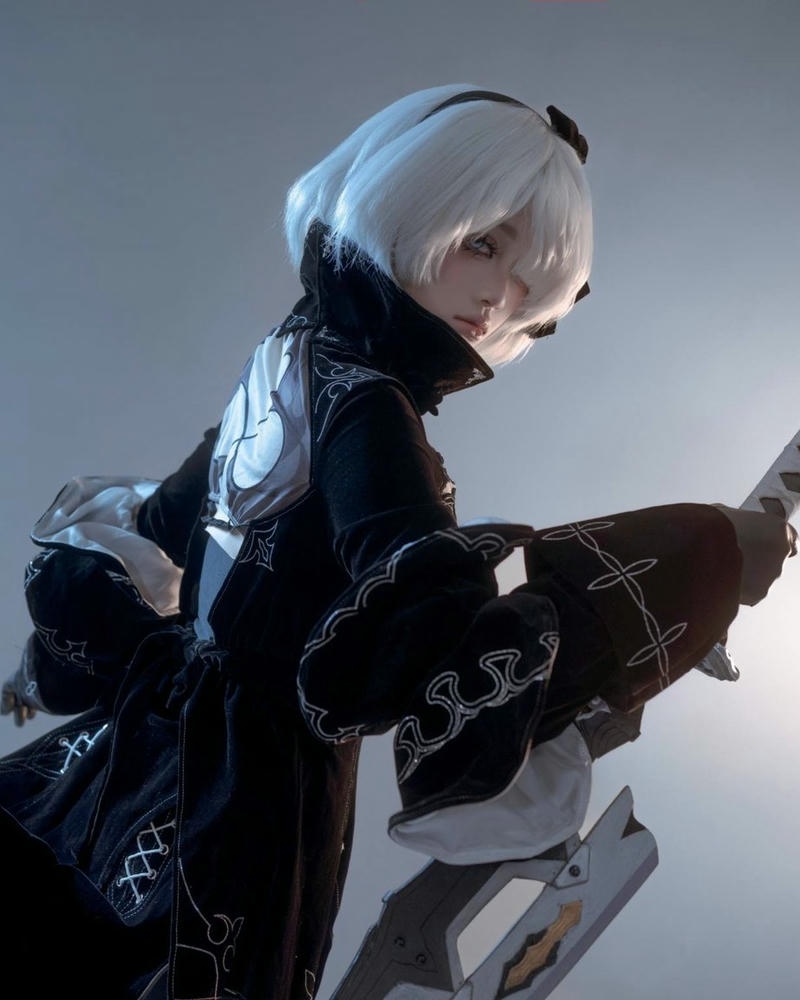 Gái xinh cosplay tóc trắng mặc đồ đen cầm súng