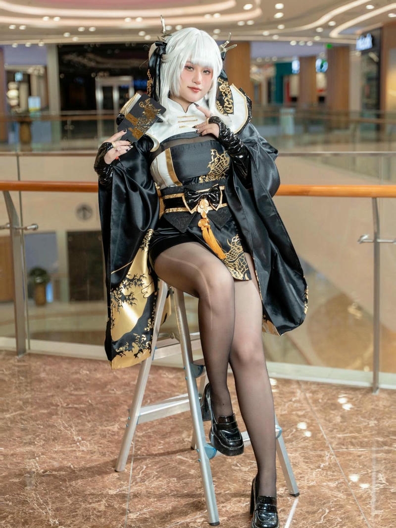 Hóa trang nhân vật nữ tóc trắng váy đen ngồi ghế